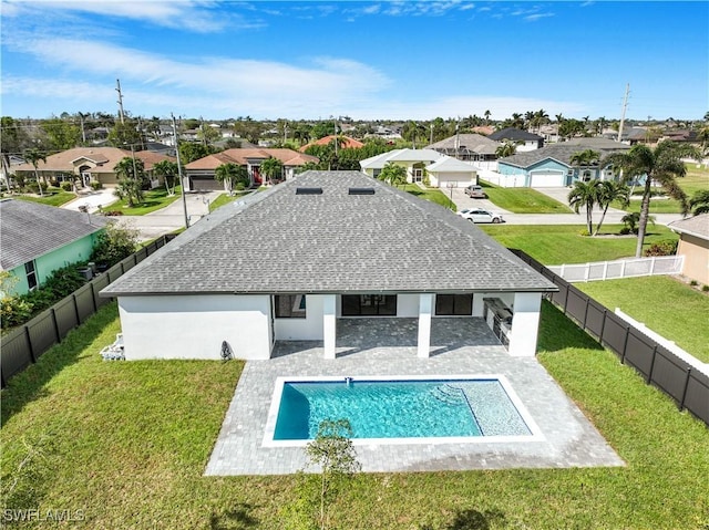 rear view of property with a yard, a fenced in pool, and a patio area