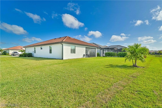 back of property with a lawn and a lanai