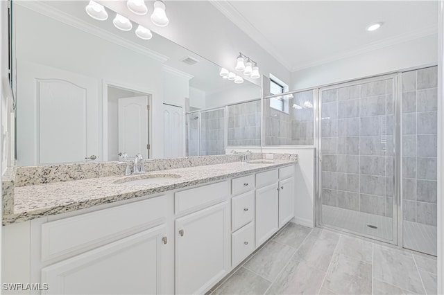 bathroom with a shower with shower door, vanity, and ornamental molding