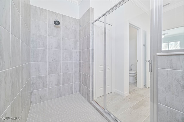 bathroom with crown molding, a tile shower, and toilet