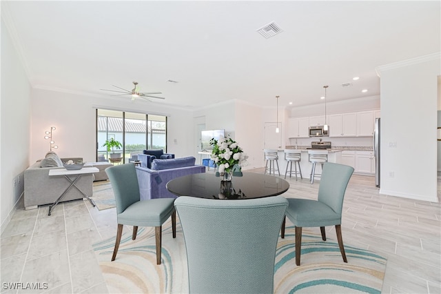 dining space featuring ornamental molding and ceiling fan