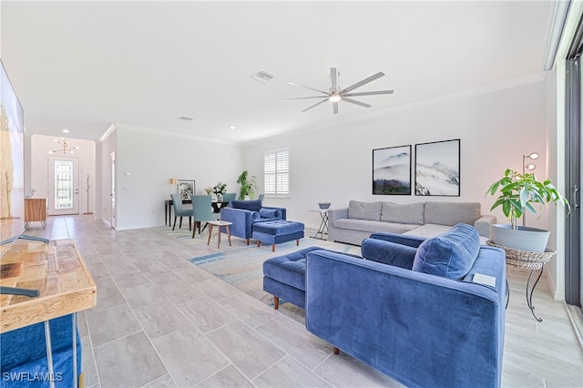 living room with ceiling fan with notable chandelier and crown molding