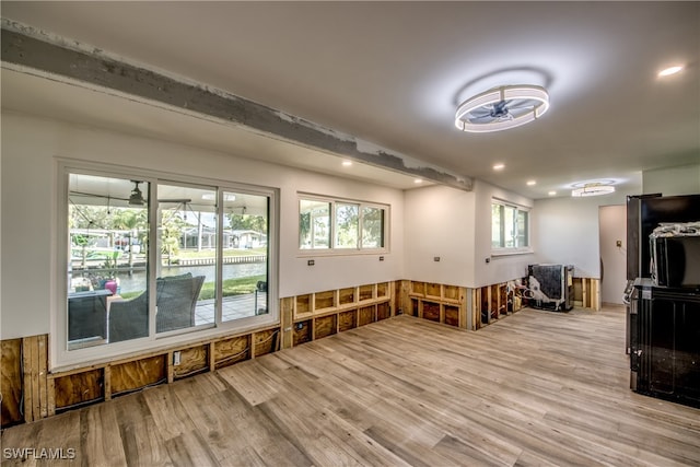 interior space featuring light hardwood / wood-style floors, beam ceiling, and ceiling fan