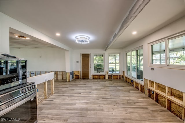 miscellaneous room featuring beam ceiling and light wood-type flooring