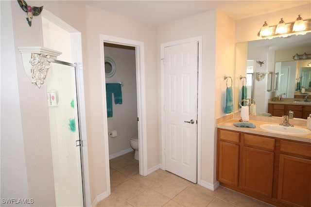 bathroom featuring vanity, an enclosed shower, toilet, and tile patterned floors