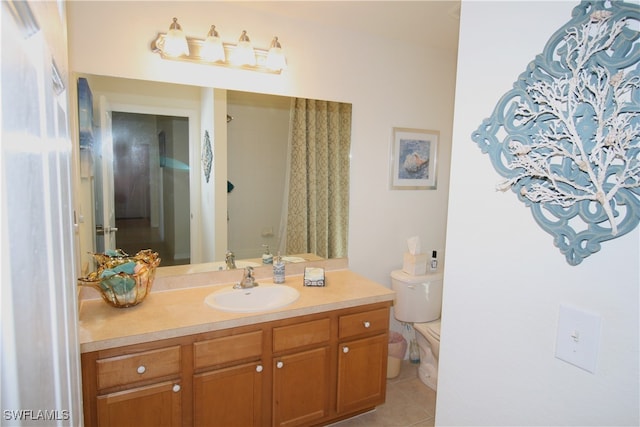 bathroom with toilet, vanity, and tile patterned floors