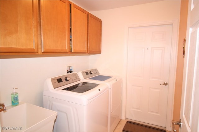 laundry room with cabinets, sink, tile patterned floors, and washing machine and clothes dryer