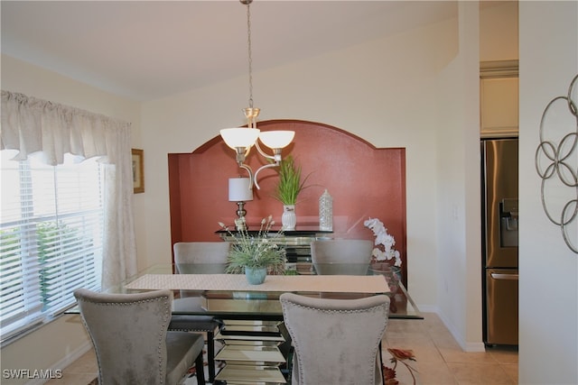 tiled dining space with vaulted ceiling and a notable chandelier