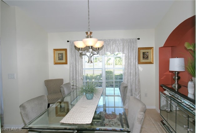 tiled dining space featuring an inviting chandelier