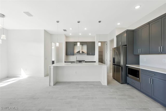 kitchen featuring stainless steel appliances, light countertops, visible vents, a sink, and wall chimney exhaust hood