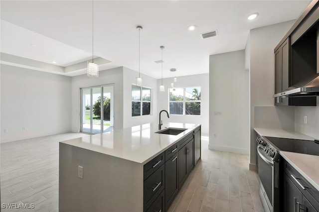 kitchen with light wood-style flooring, electric stove, a sink, and wall chimney range hood