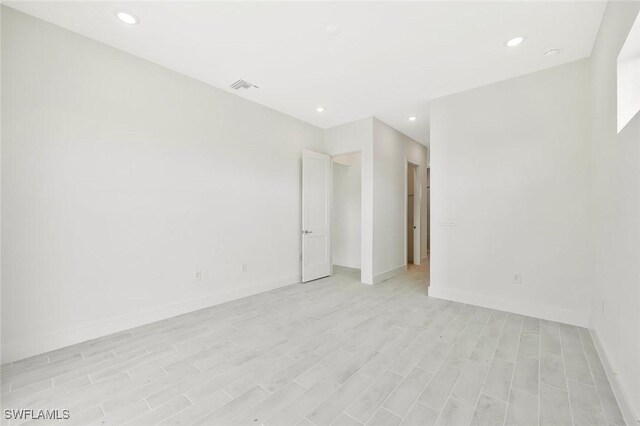 unfurnished room with light wood-style floors, baseboards, visible vents, and recessed lighting