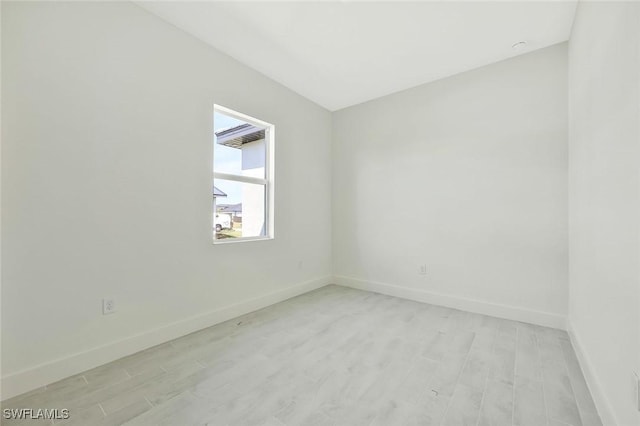 unfurnished room with light wood-type flooring and baseboards