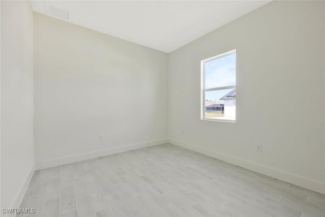 spare room featuring light wood finished floors and baseboards