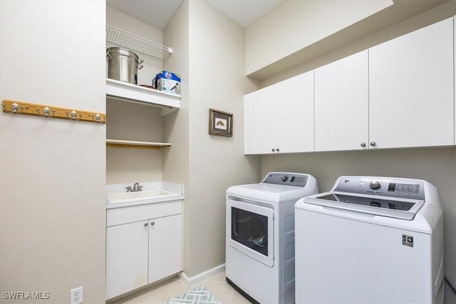 clothes washing area with washer and dryer, cabinets, and sink