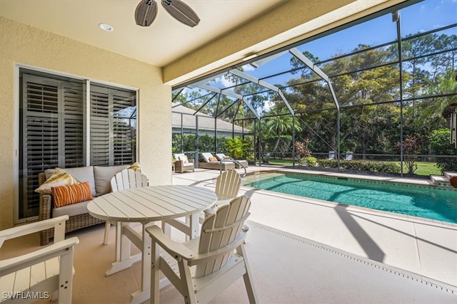 view of pool featuring glass enclosure, ceiling fan, and a patio