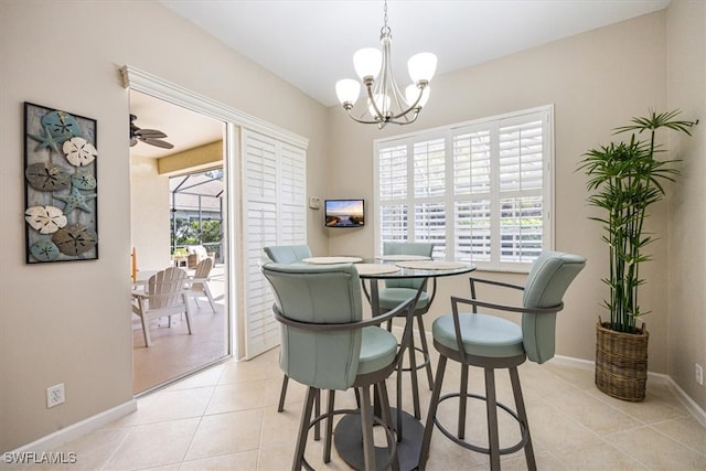 tiled dining space with a wealth of natural light and ceiling fan with notable chandelier