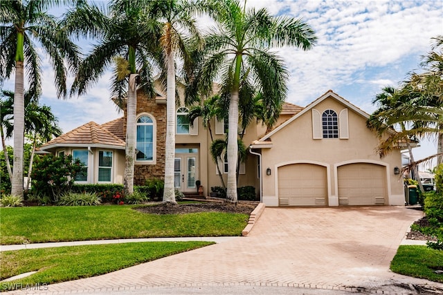 mediterranean / spanish-style home with a front lawn and a garage