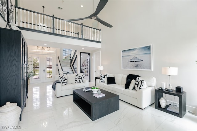 living room with a high ceiling and ceiling fan