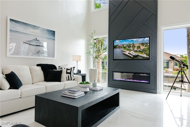 living room featuring a towering ceiling and a fireplace