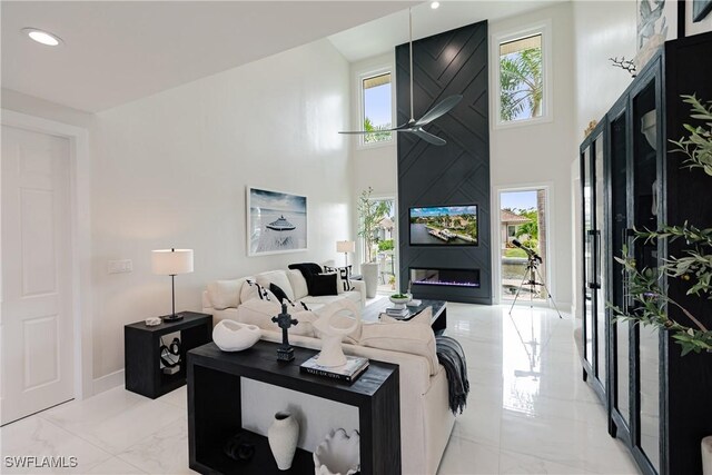 1045 Cottonwood Ct, Marco Island, FL 34145 - living area with light marble finish flooring, a towering ceiling, baseboards, and recessed lighting