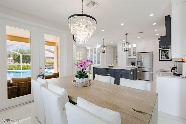 1045 Cottonwood Ct, Marco Island, FL 34145 - dining space with a chandelier, recessed lighting, light marble finish flooring, and french doors