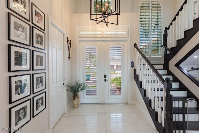 1045 Cottonwood Ct, Marco Island, FL 34145 - foyer entrance with french doors, a chandelier, marble finish floors, stairway, and baseboards