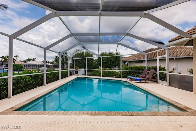 view of swimming pool with a patio area and a lanai