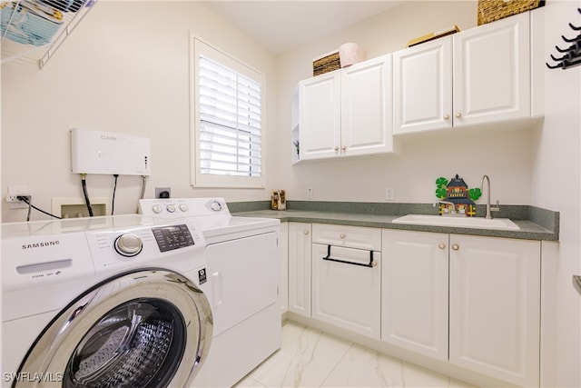 washroom with cabinets, washer and dryer, and sink