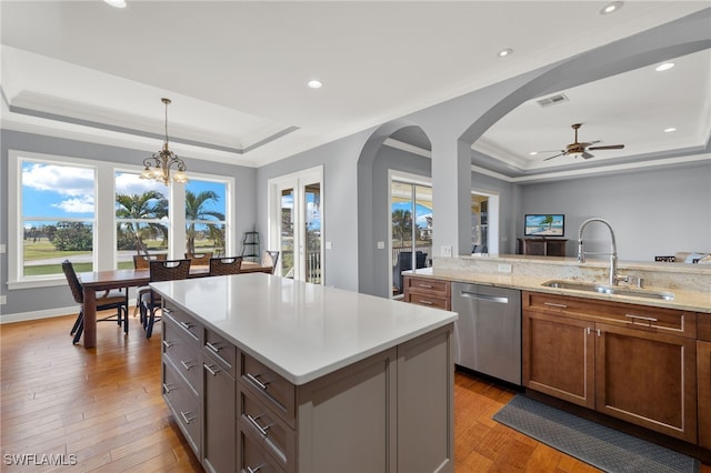 kitchen featuring sink, a raised ceiling, and a center island