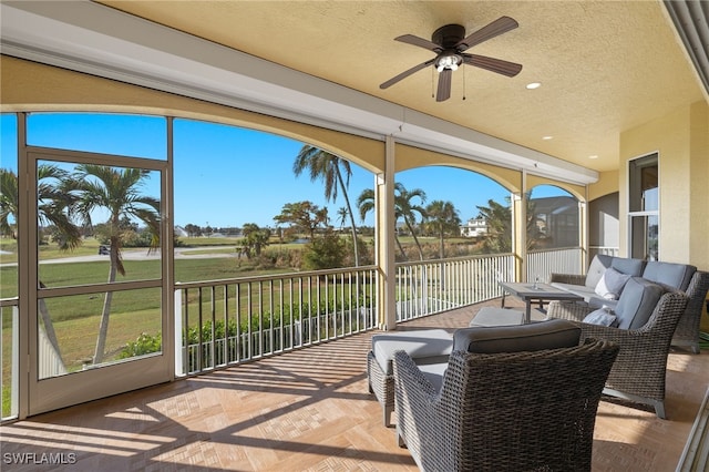 sunroom featuring ceiling fan and plenty of natural light