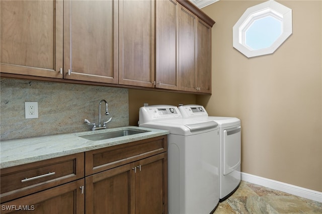 clothes washing area featuring cabinets, sink, crown molding, and independent washer and dryer