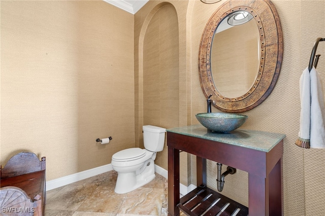 bathroom featuring ornamental molding, sink, and toilet