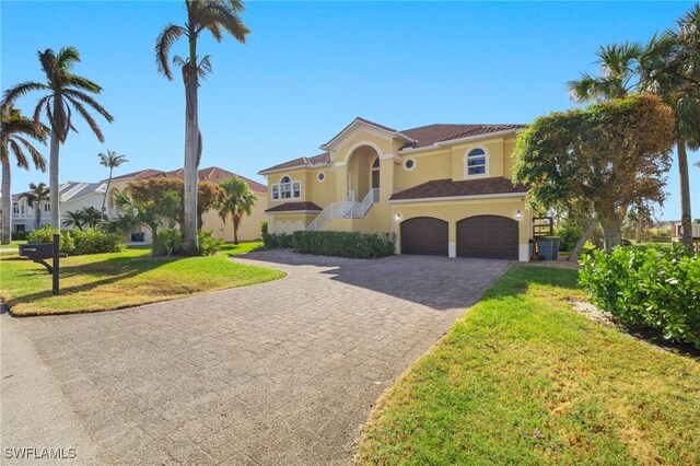 mediterranean / spanish-style home with a garage and a front lawn