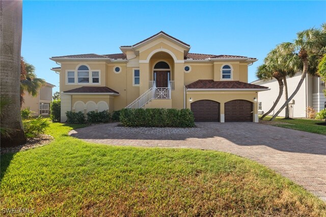 mediterranean / spanish-style home featuring a front lawn and a garage