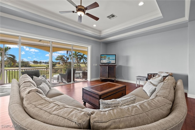 living room with dark hardwood / wood-style flooring, a raised ceiling, ceiling fan, and crown molding