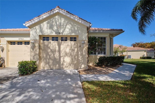 mediterranean / spanish home featuring a front yard and a garage