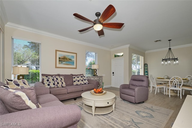 living room with a wealth of natural light, hardwood / wood-style floors, and crown molding