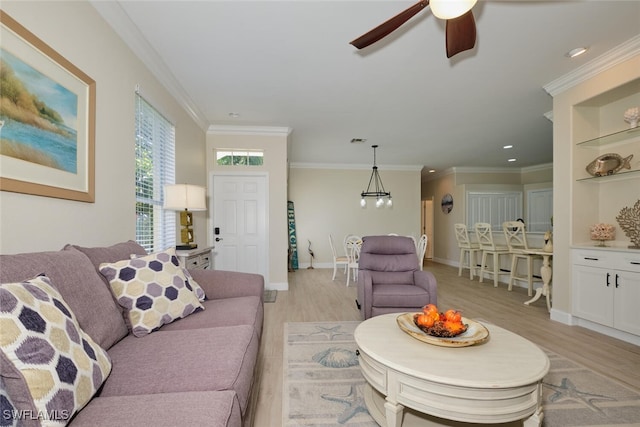 living room featuring ornamental molding, light hardwood / wood-style flooring, and ceiling fan with notable chandelier