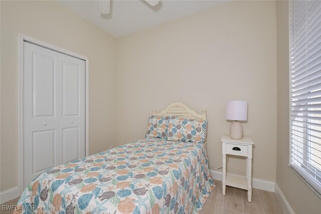 bedroom with light hardwood / wood-style floors, a closet, and ceiling fan