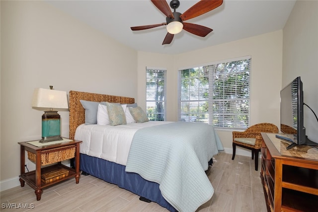 bedroom featuring light hardwood / wood-style flooring, multiple windows, and ceiling fan