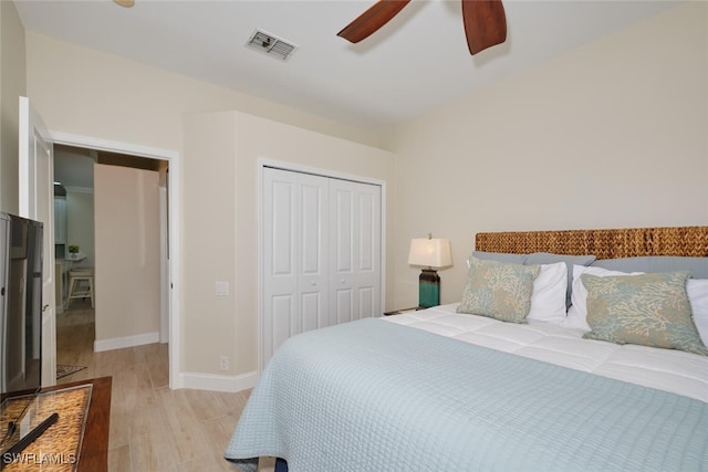 bedroom featuring a closet, light hardwood / wood-style floors, and ceiling fan