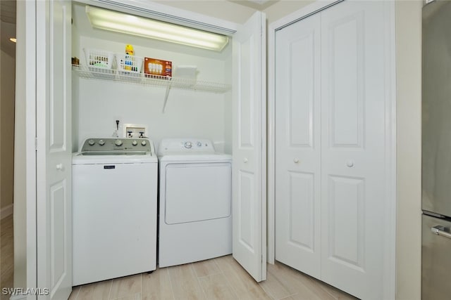 washroom with light wood-type flooring and separate washer and dryer