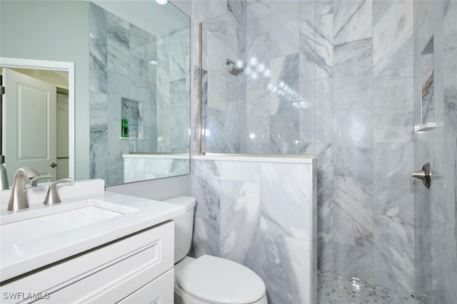 bathroom featuring a tile shower, toilet, and vanity