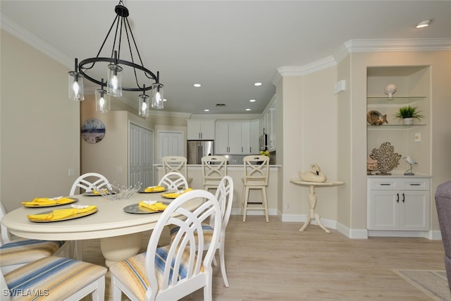 dining room featuring light hardwood / wood-style floors, crown molding, and a chandelier