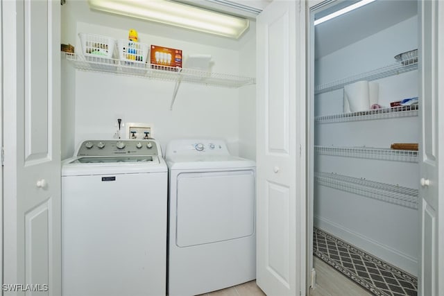 clothes washing area featuring light hardwood / wood-style floors and separate washer and dryer