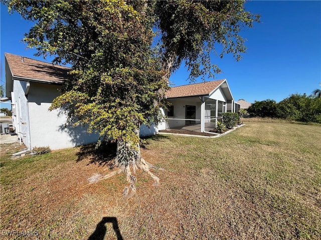 rear view of house with a sunroom and a yard