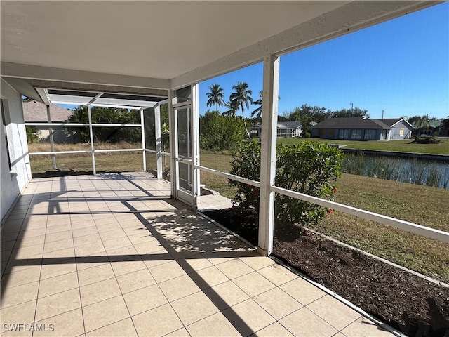 unfurnished sunroom featuring a water view