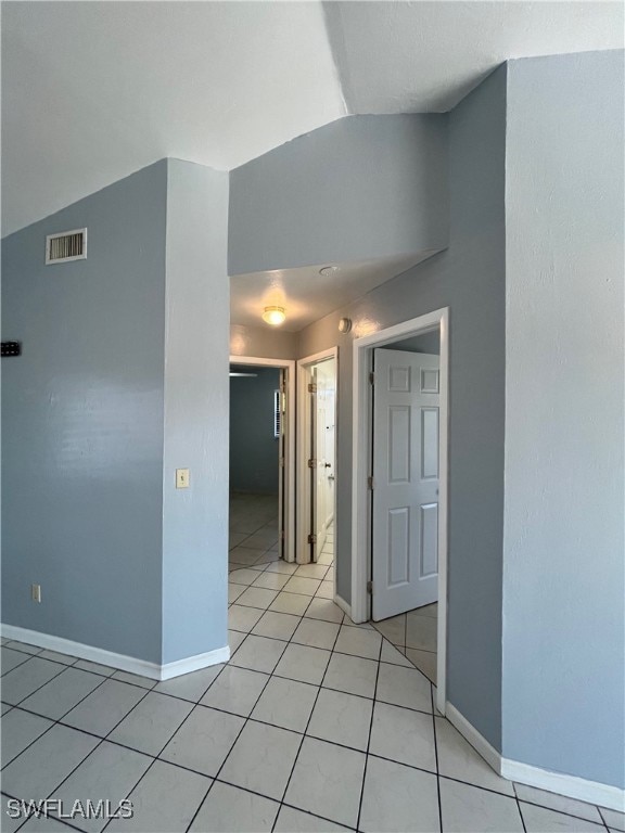 tiled spare room with lofted ceiling