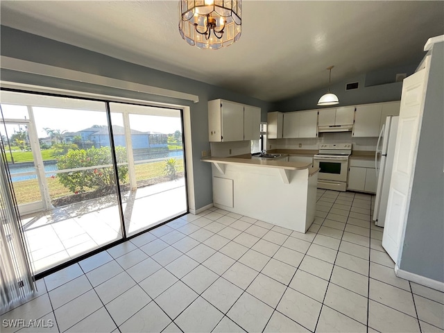 kitchen featuring white appliances, vaulted ceiling, light tile patterned floors, decorative light fixtures, and kitchen peninsula